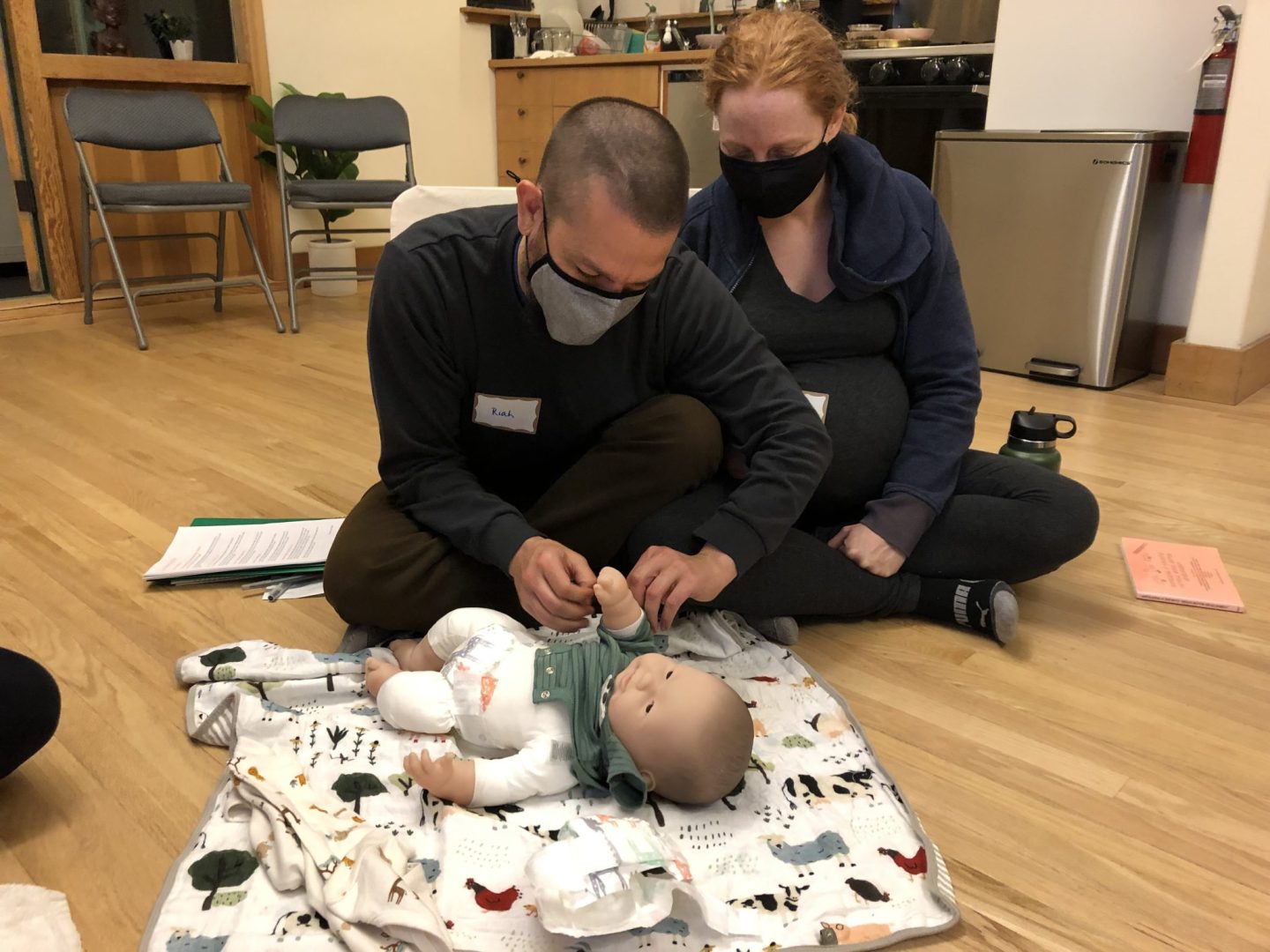 Parents at a RIE® Before Baby™ Course practice a diaper change modeling the RIE Principles and Practices they explored during the class.