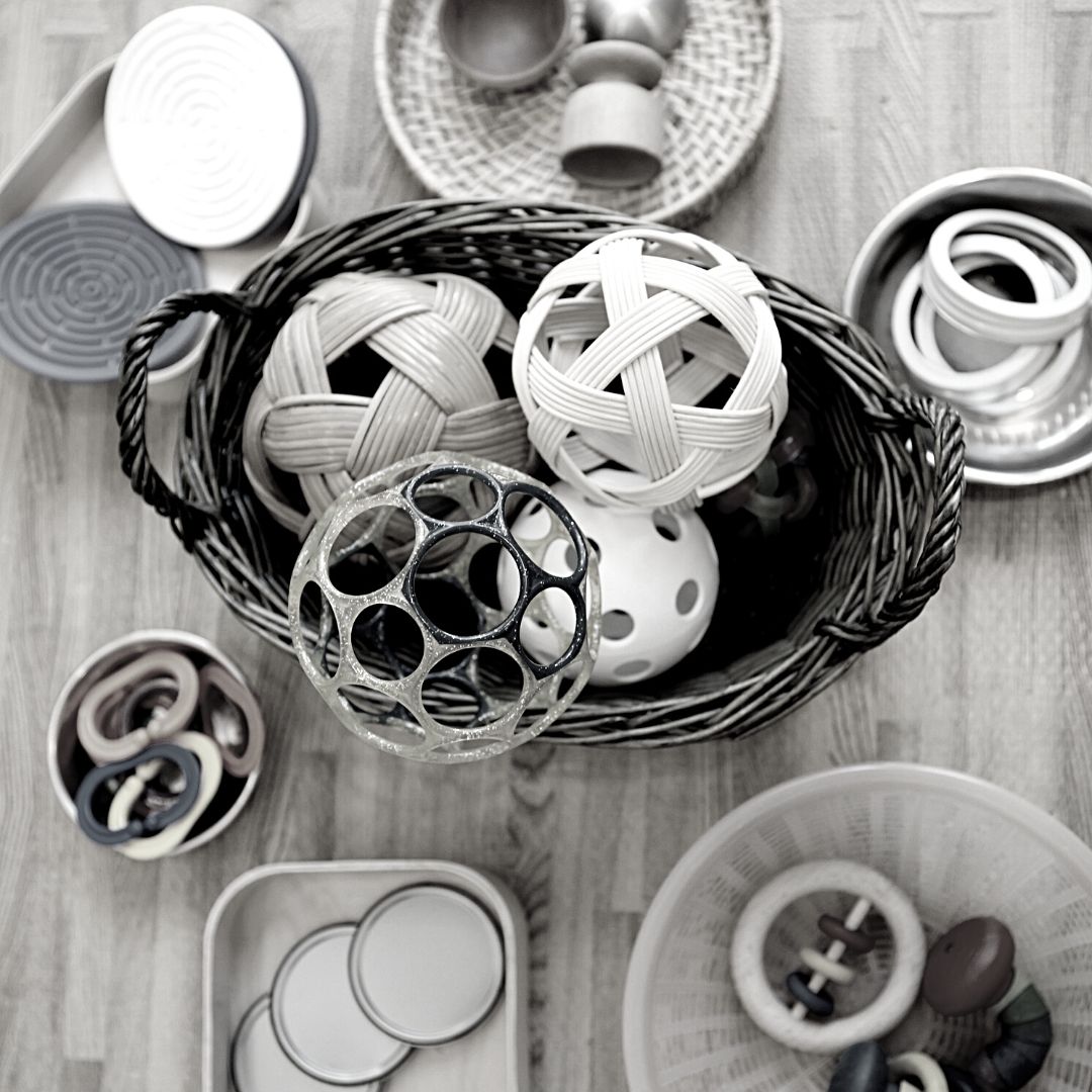 An assortment of balls, rings, and circle objects of different textures and materials used during RIE® Parent Infant Guidance™ Class