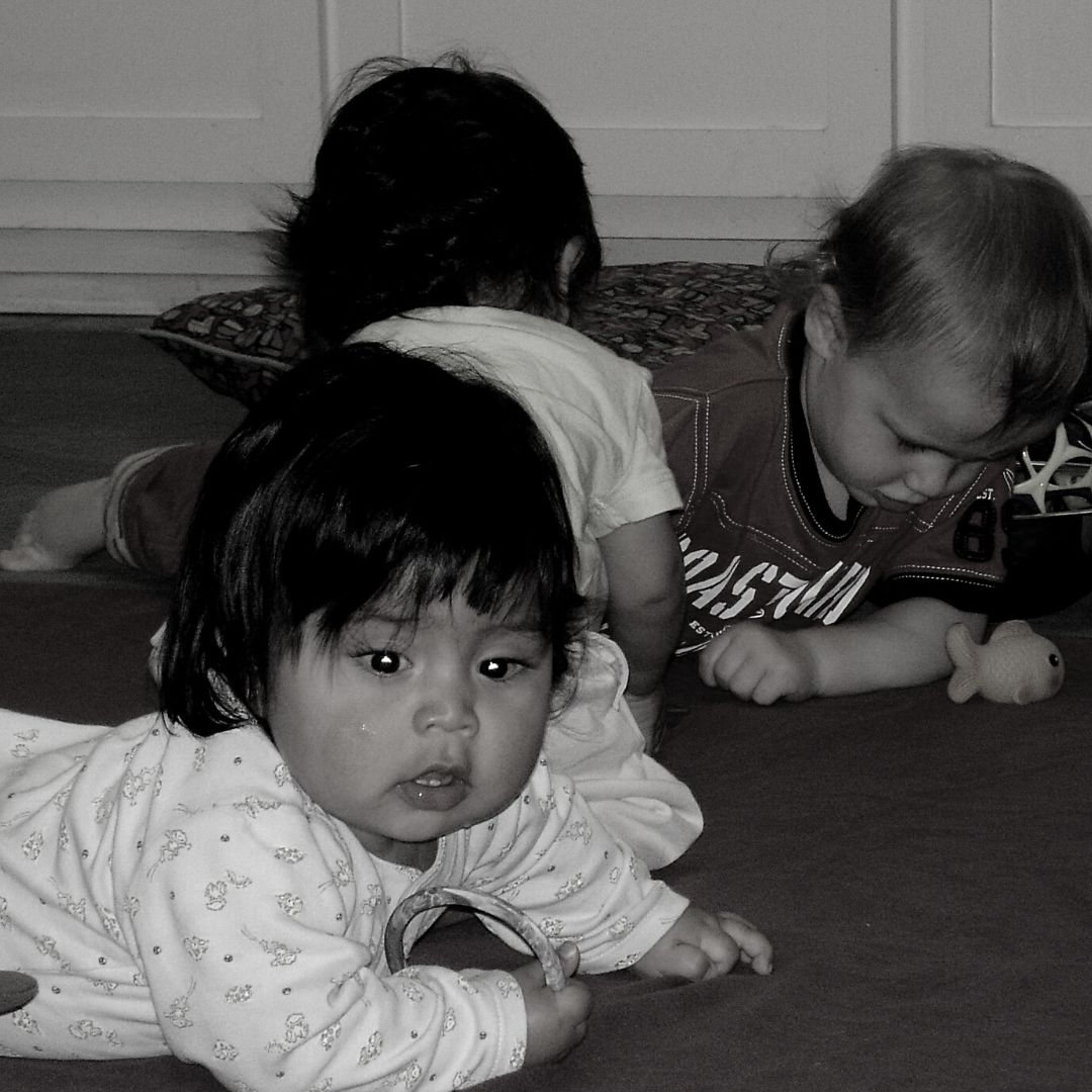 Three babies crawling on the floor during a RIE® Parent Infant Guidance™ Class